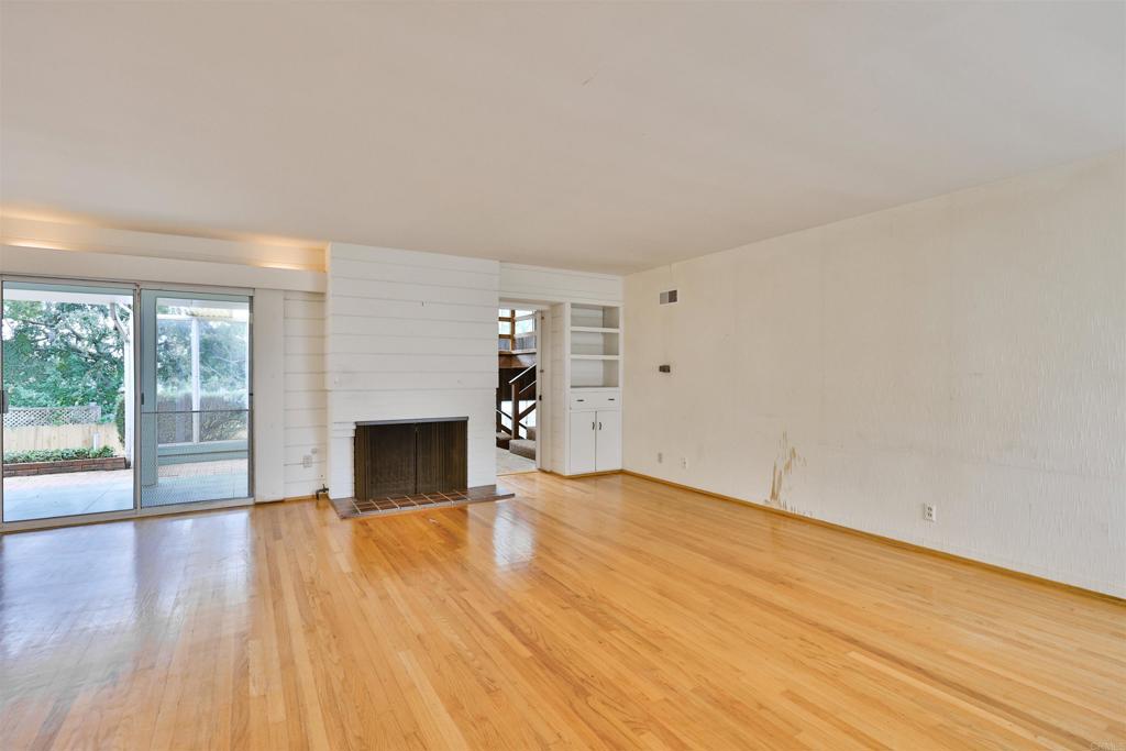 5930 Waverly Avenue La Jolla, CA 92037 - Photo 30 of 61 a view of empty room with wooden floor and fireplace