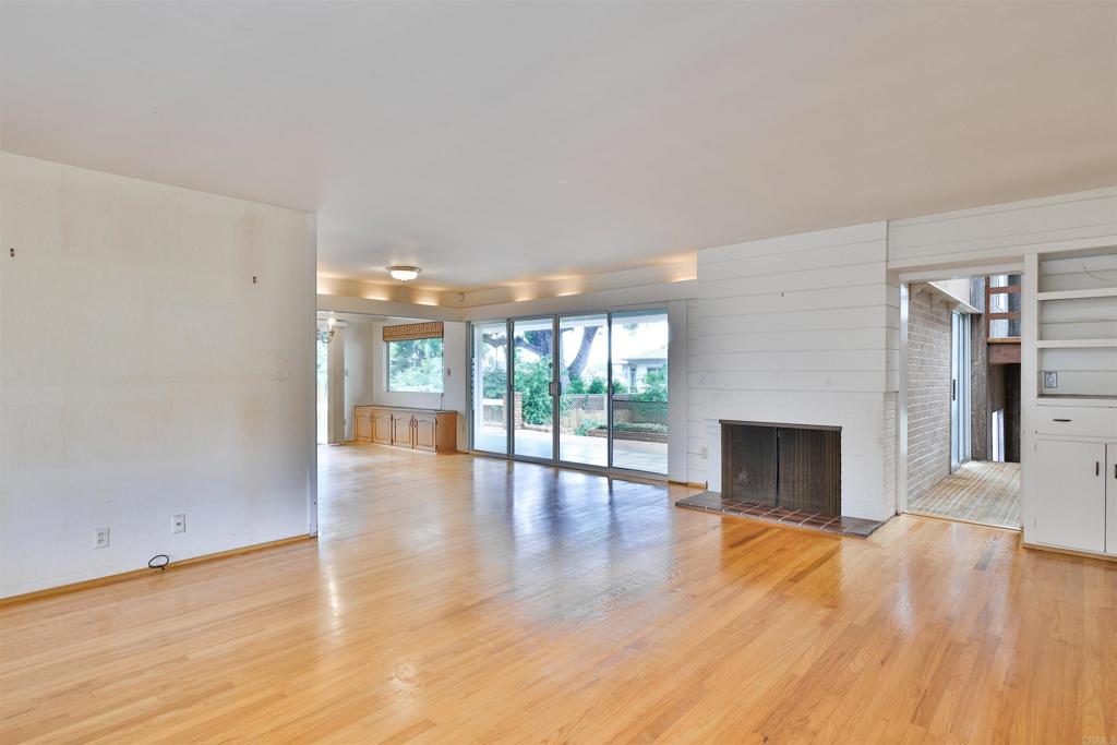 5930 Waverly Avenue La Jolla, CA 92037 - Photo 32 of 61 a view of an empty room with wooden floor and a fireplace