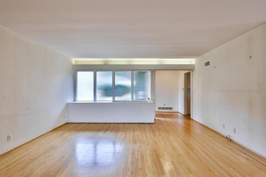 5930 Waverly Avenue La Jolla, CA 92037 - Photo 35 of 61 an empty room with wooden floor and glass door