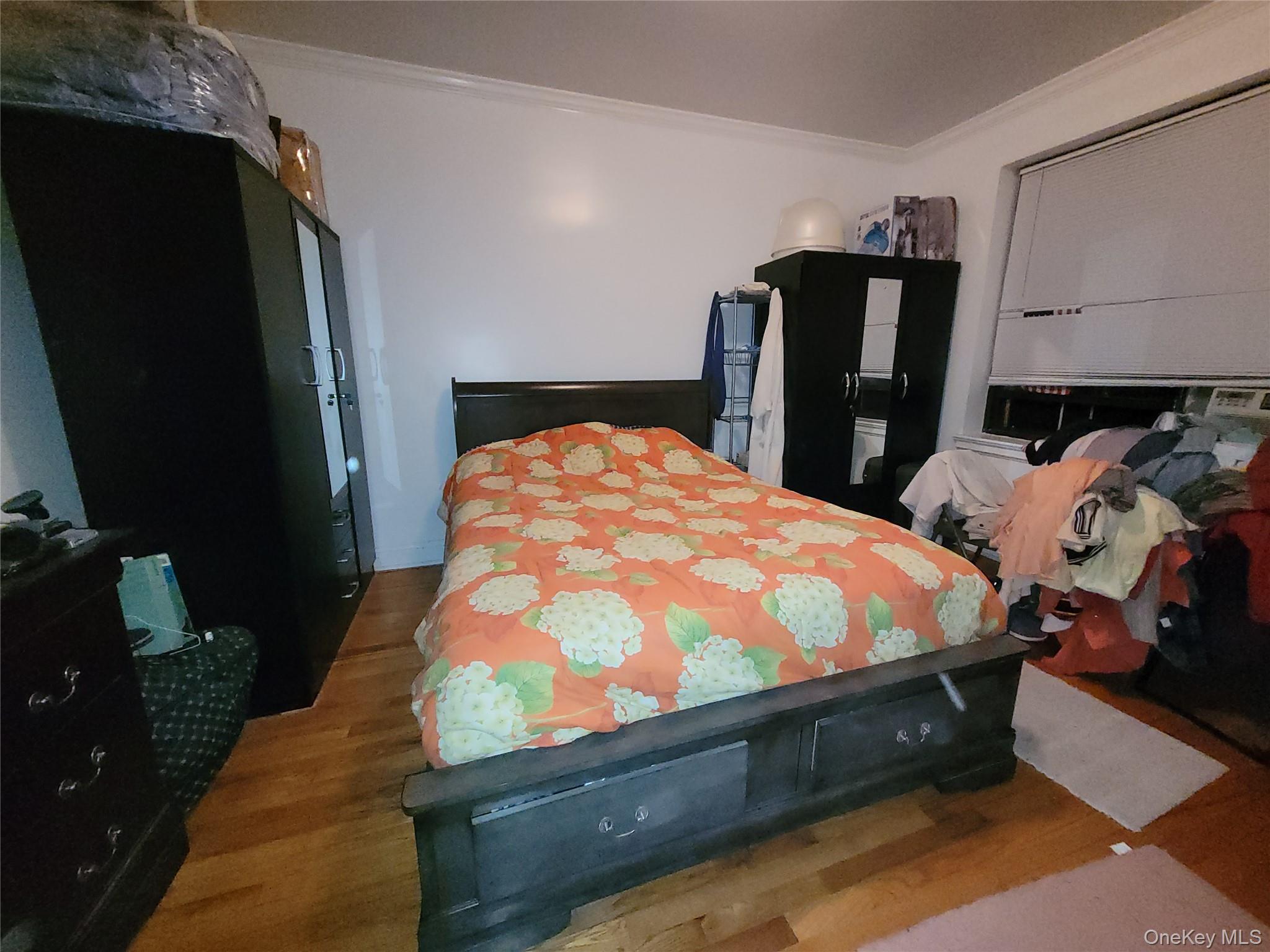 2209 76th Street, Unit C2 Queens, NY 11370 - Photo 4 of 5 a bed sitting in a bedroom next to a window