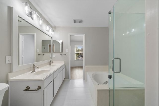 a bathroom with a double vanity sink a mirror and shower