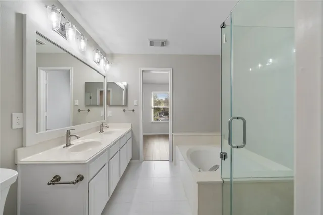 a bathroom with a double vanity sink a mirror and shower