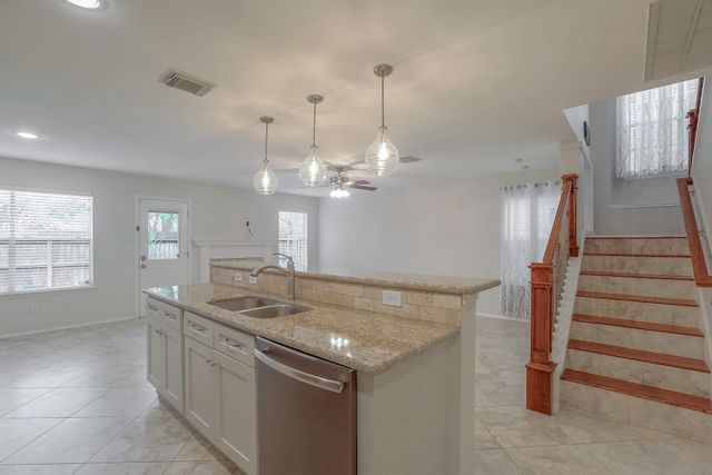 a kitchen with stainless steel appliances granite countertop a sink and a refrigerator