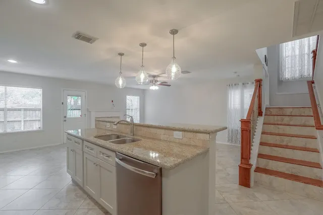 a kitchen with stainless steel appliances granite countertop a sink and a refrigerator