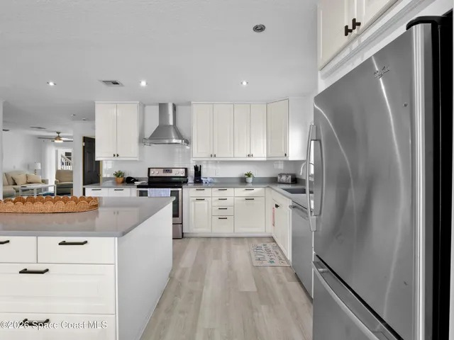 a large kitchen with stainless steel appliances granite countertop a stove a sink dishwasher and a refrigerator