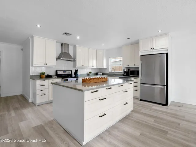 a kitchen with white cabinets and counter
