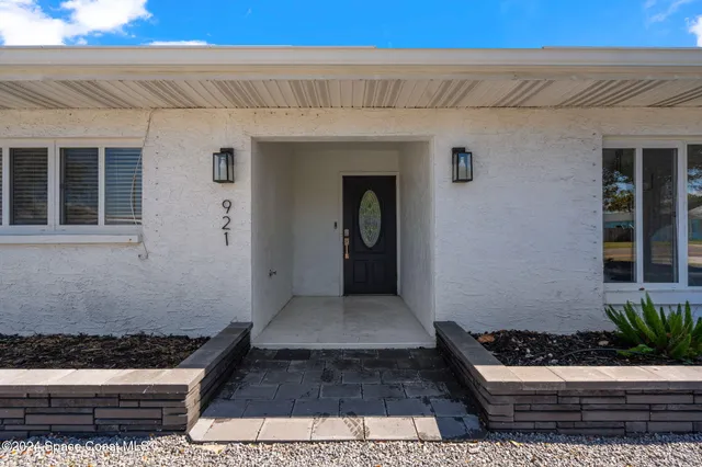 a front view of a house with plants
