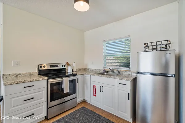 a living room with furniture a flat screen tv and kitchen view