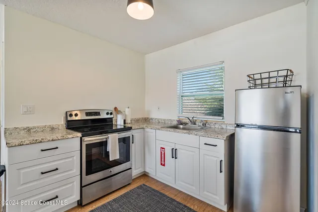 a living room with furniture a flat screen tv and kitchen view