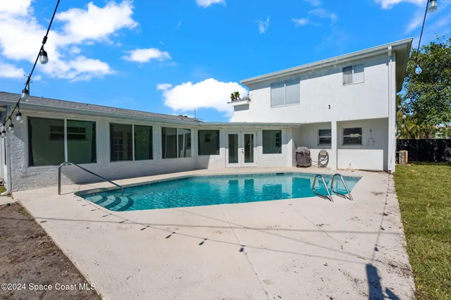 an aerial view of a house with swimming pool and garden
