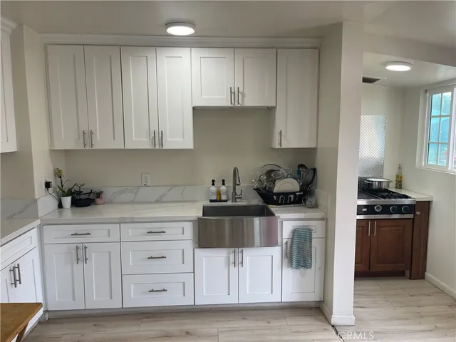 a kitchen with white cabinets and appliances