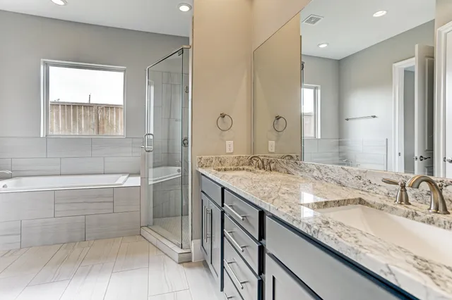 a bathroom with a granite countertop sink a mirror and a bathtub