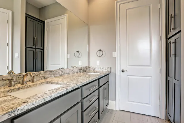 a bathroom with a granite countertop sink and a mirror