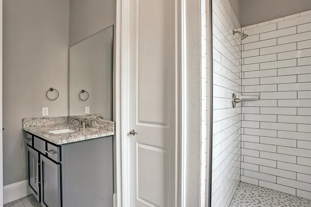 a bathroom with a granite countertop sink and mirror