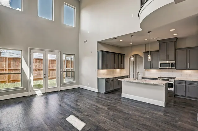 a large white kitchen with lots of counter space a sink and appliances