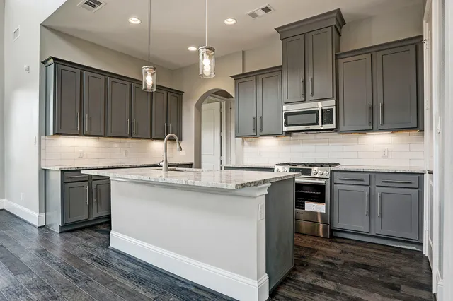 a kitchen with stainless steel appliances granite countertop a sink stove and refrigerator