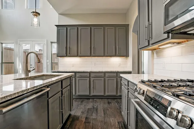 a kitchen with stainless steel appliances granite countertop a stove and a sink