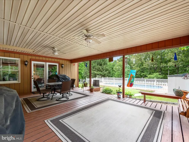a view of a swimming pool with a yard and fence