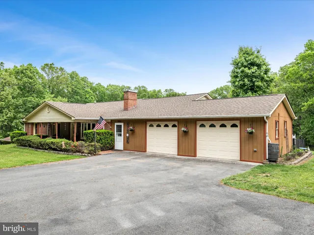 a front view of a house with garden and sitting area