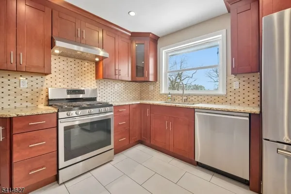 a kitchen with granite countertop cabinets stainless steel appliances and a sink