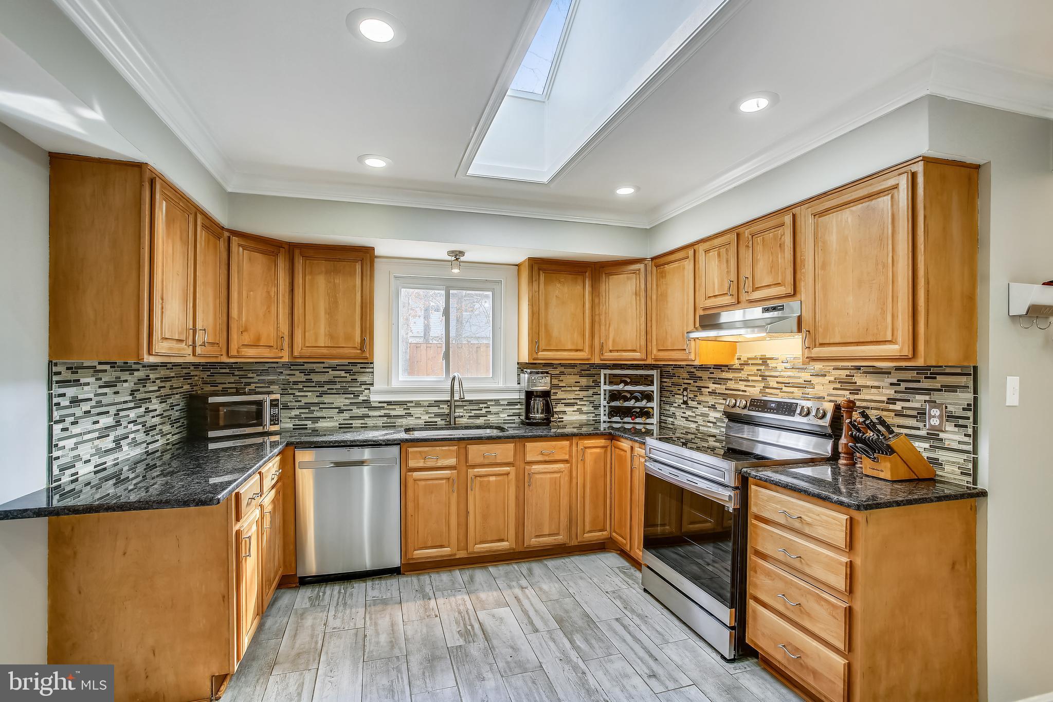 6005 Filbert Court Springfield, VA 22152 - Photo 21 of 55 a kitchen with stainless steel appliances granite countertop wooden cabinets a sink dishwasher a stove and a refrigerator with wooden floor