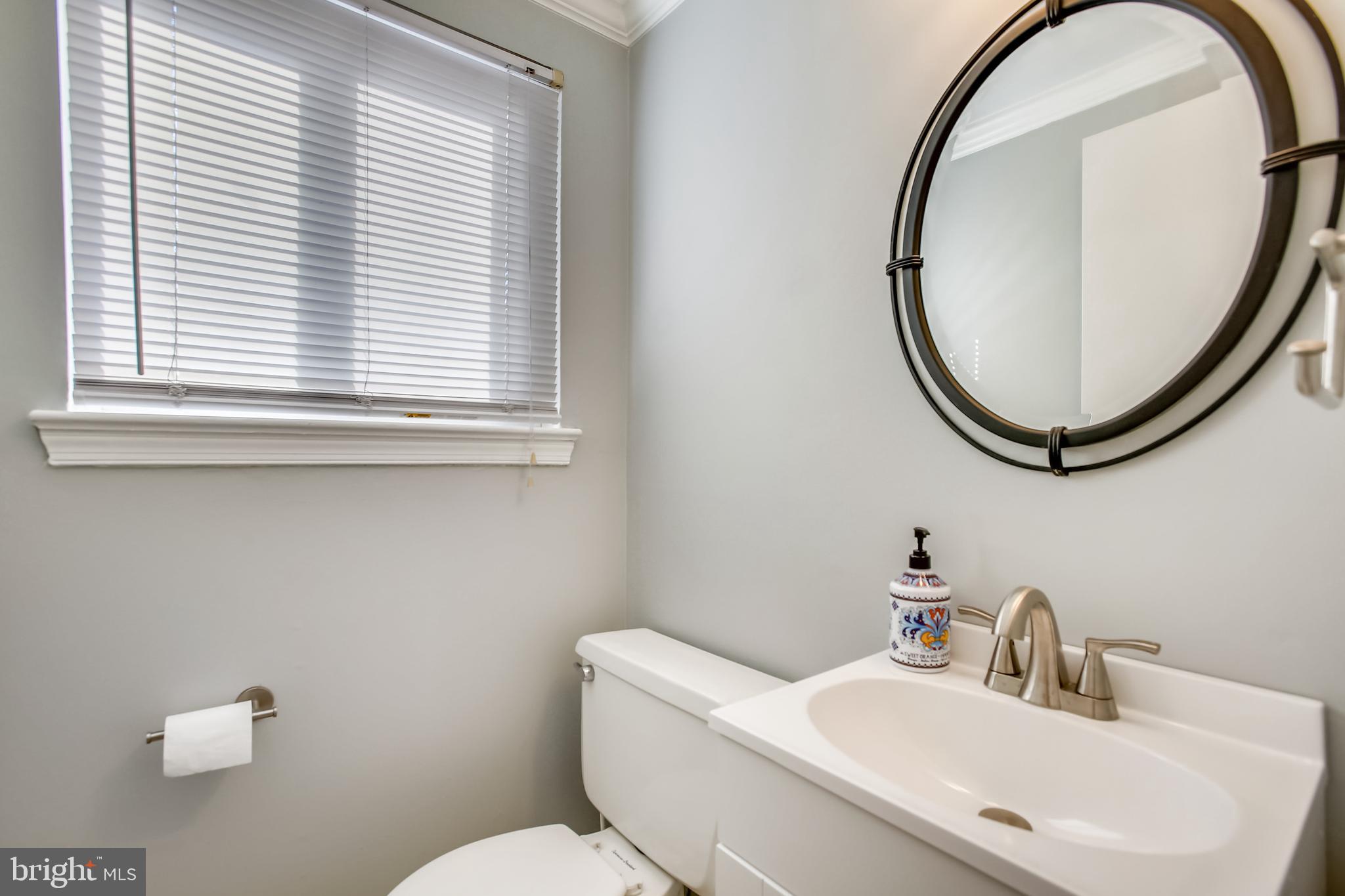 6005 Filbert Court Springfield, VA 22152 - Photo 27 of 55 a bathroom with a sink a mirror a toilet and a window