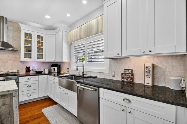 a kitchen with granite countertop white cabinets and white appliances