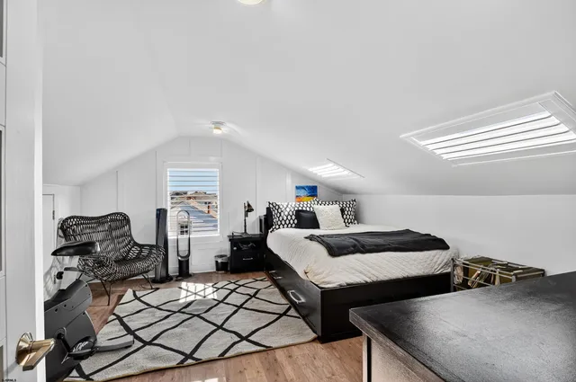 a living room with furniture and a dining table with wooden floor
