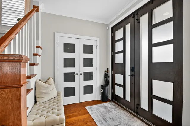 a living room with a black white checkered floor with a large window and stainless steel appliances