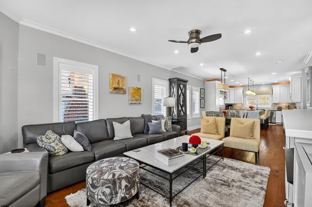 a living room with furniture and a dining table with wooden floor