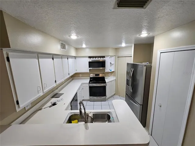 a kitchen with a refrigerator and a stove top oven