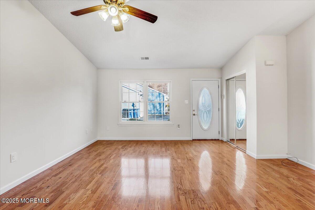5 Jaffreyton Close Freehold, NJ 07728 - Photo 18 of 39 an empty room with wooden floor chandelier fan and windows