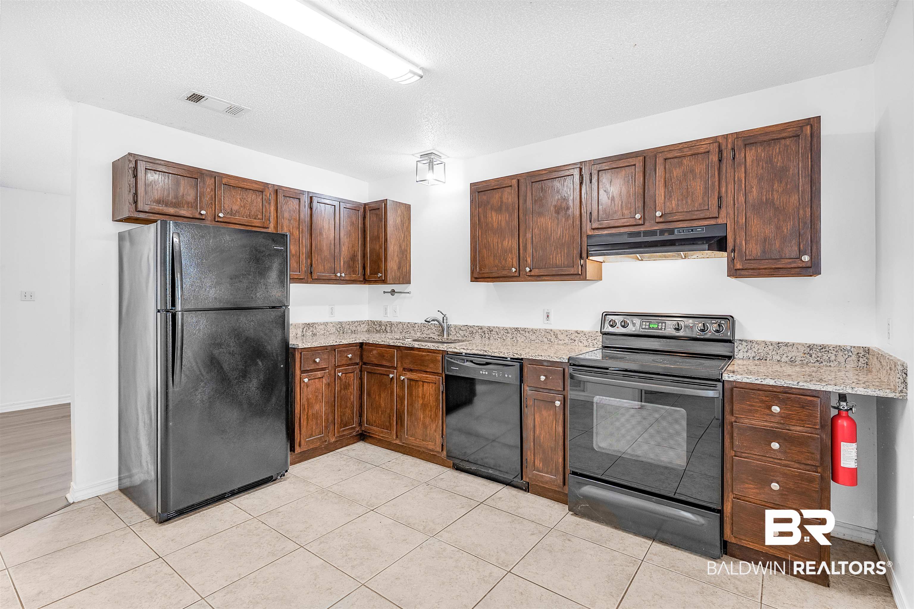 14919 Daugherty Road Foley, AL 36535 - Photo 17 of 27 Kitchen featuring black appliances, sink, a textured ceiling, light stone counters, and light tile patterned floors