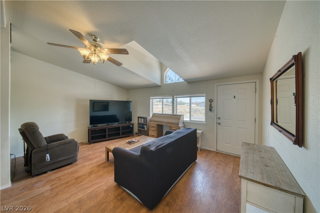 2931 Rio Rancho Drive, Unit 4 Pahrump, NV 89048 - Photo 4 of 21 Natural light streams into this living area with vaulted ceilings and rich wood flooring.