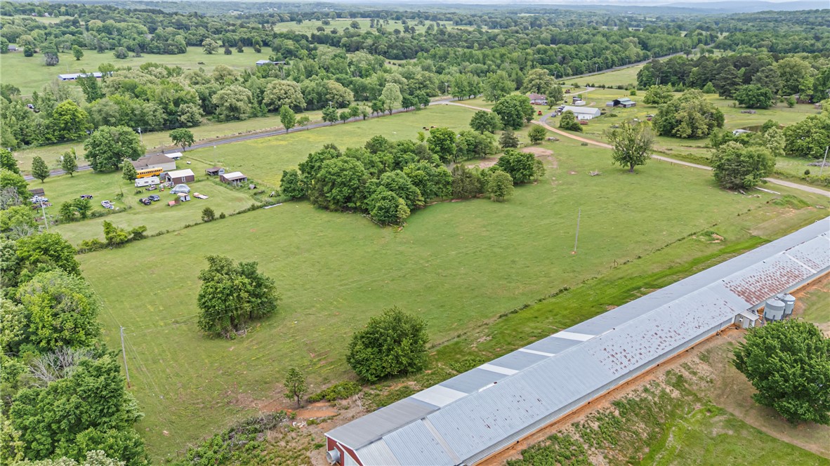 0 Wire Road Mulberry, AR 72947 - Photo 10 of 31 Extensive agricultural property featuring a long, red-sided building with a metal roof and multiple silver silos
