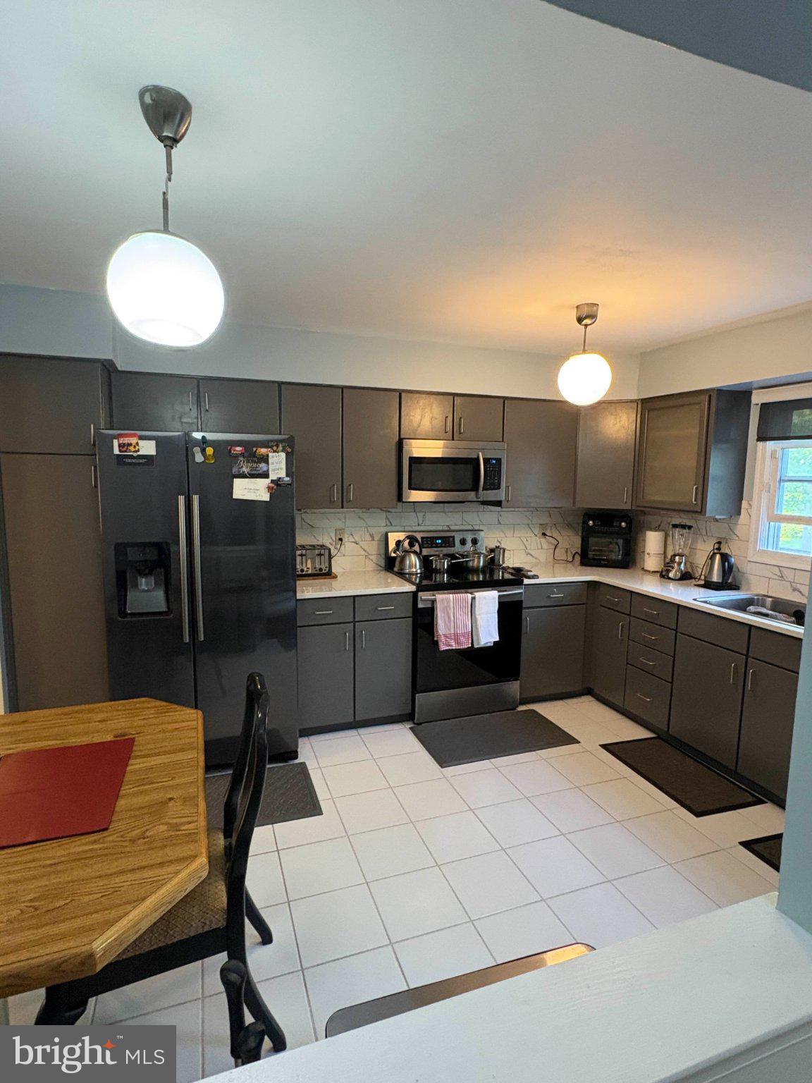5 Corlen Court, Unit 5 Medford, NJ 08055 - Photo 8 of 33 a kitchen with stainless steel appliances kitchen island granite countertop a sink a stove a refrigerator cabinets and a chairs