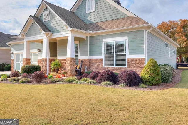 a view of a house with backyard and sitting area