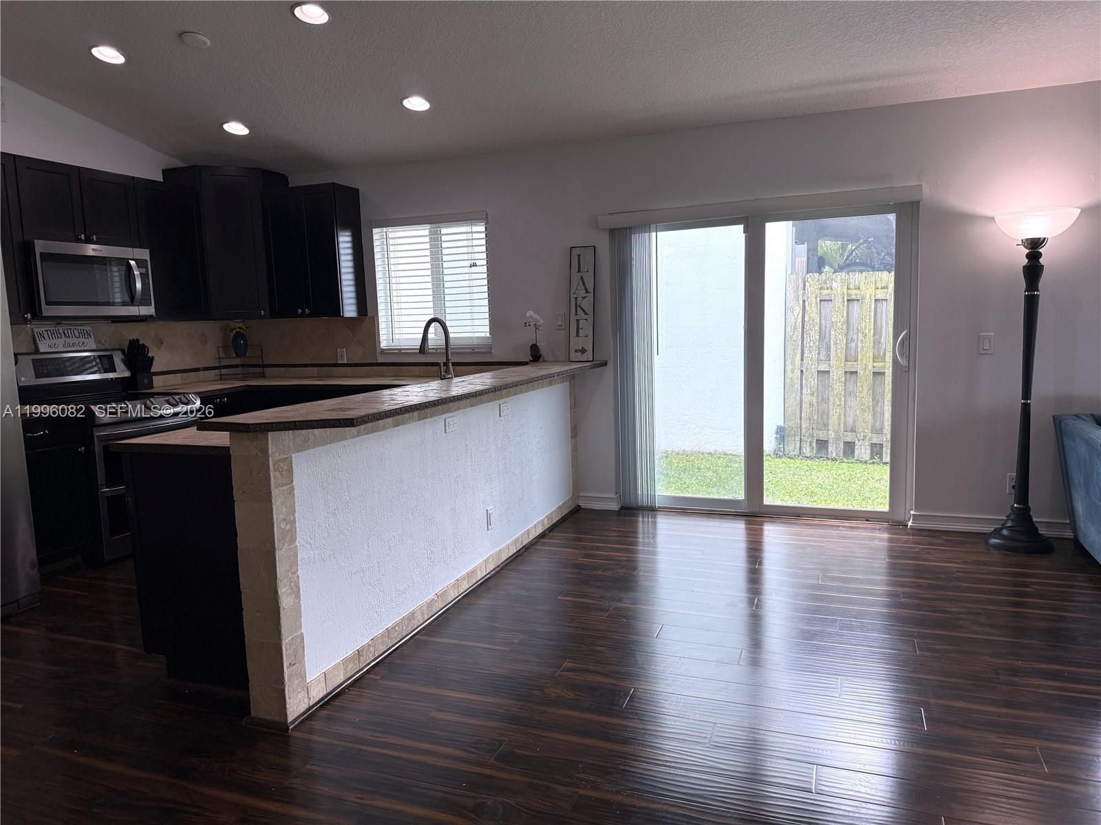 3091 Lighthouse Place Margate, FL 33063 - Photo 16 of 38 a kitchen with stainless steel appliances granite countertop a stove a sink and a microwave