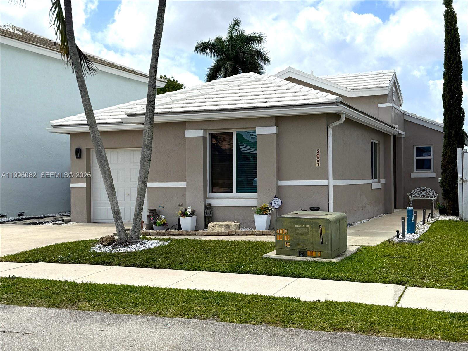3091 Lighthouse Place Margate, FL 33063 - Photo 10 of 38 a front view of a house with garden