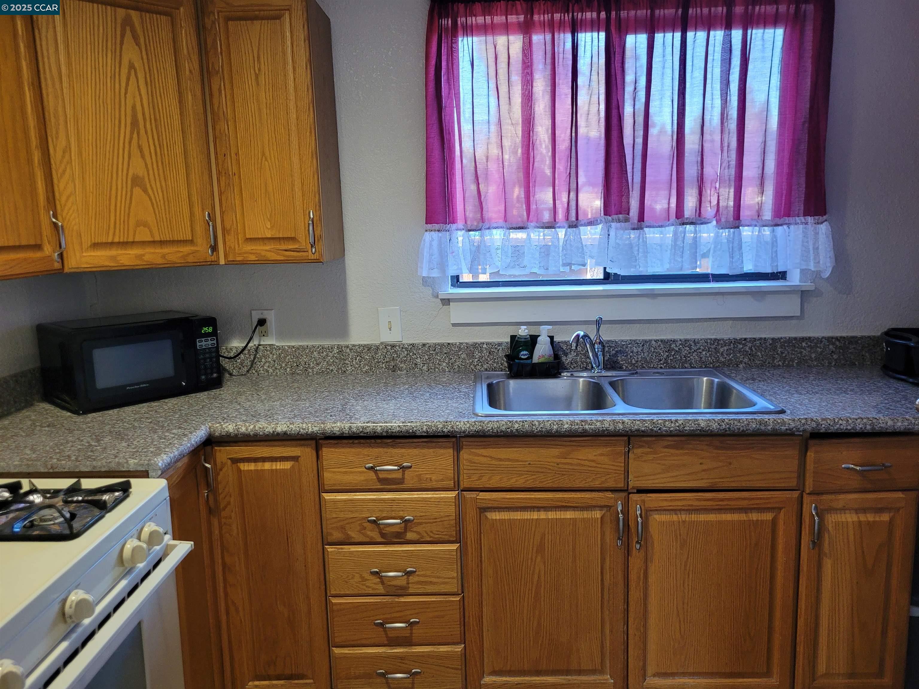 1181 Danville Boulevard, Unit E Alamo, CA 94507 - Photo 7 of 11 a kitchen with stainless steel appliances granite countertop a sink a stove and a window