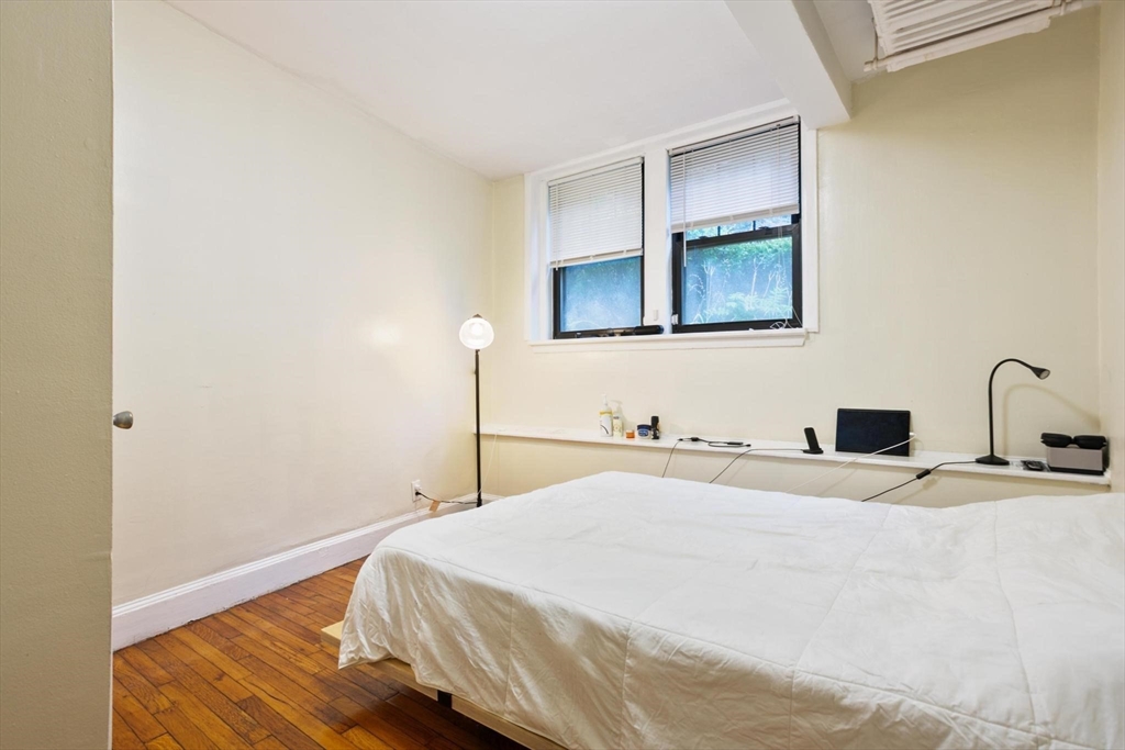 55 A Lanark Road, Unit A Boston, MA 02135 - Photo 10 of 18 a bedroom with a bed and a dresser with wooden floor