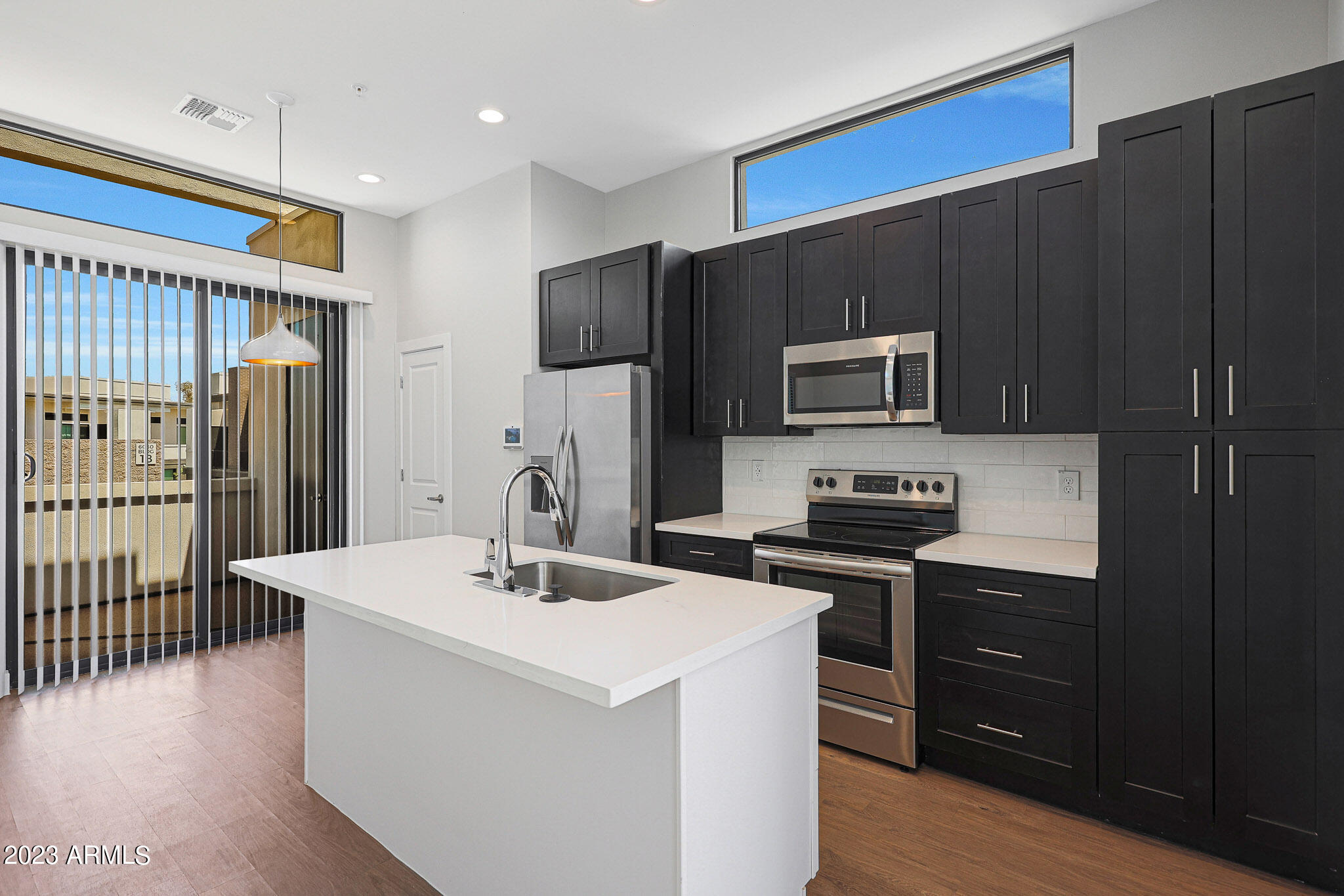 6060 East Baseline Road, Unit 138 Mesa, AZ 85206 - Photo 26 of 45 a kitchen with a sink a microwave a refrigerator and cabinets