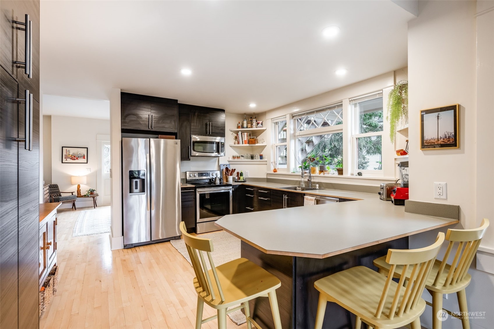 926 18th Avenue Seattle, WA 98122 - Photo 8 of 38 a kitchen with stainless steel appliances a dining table chairs refrigerator and sink