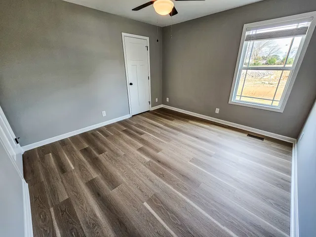 a view of room with window and wooden floor