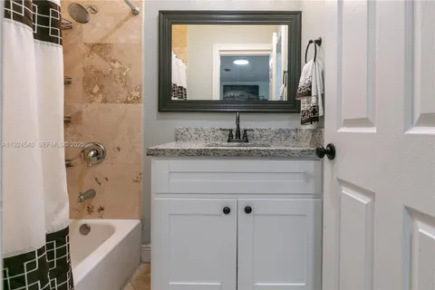 a bathroom with a granite countertop sink a toilet and a bathtub