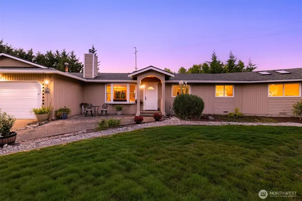 a front view of a house with a garden and a yard