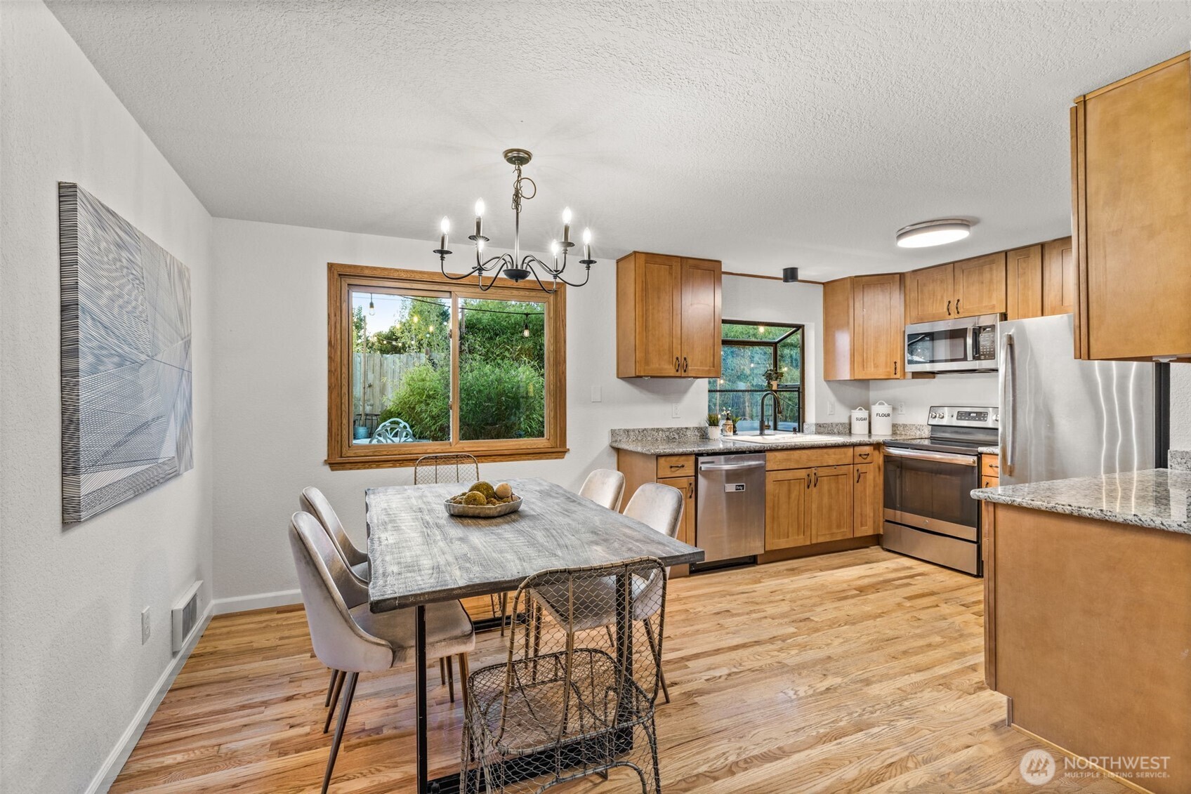 1313 228th Place Southwest Bothell, WA 98021 - Photo 5 of 23 a kitchen with a table chairs a sink dishwasher window and wooden floor