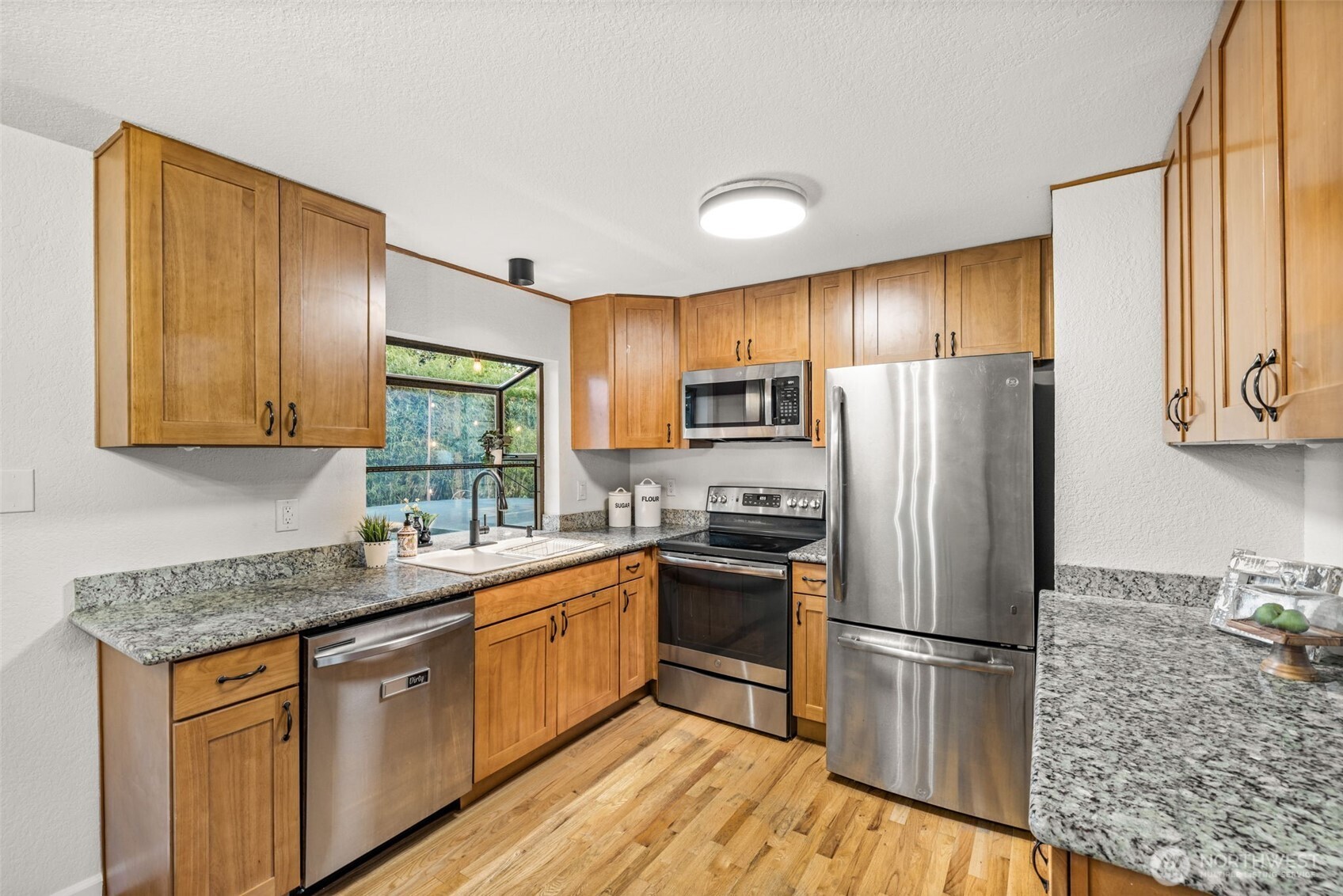 1313 228th Place Southwest Bothell, WA 98021 - Photo 6 of 23 a kitchen with stainless steel appliances granite countertop a refrigerator stove microwave and sink
