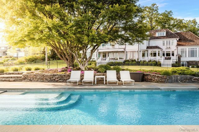 a house view with swimming pool and trees