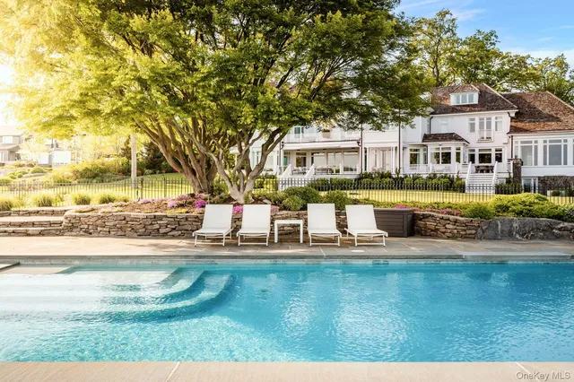 a house view with swimming pool and trees
